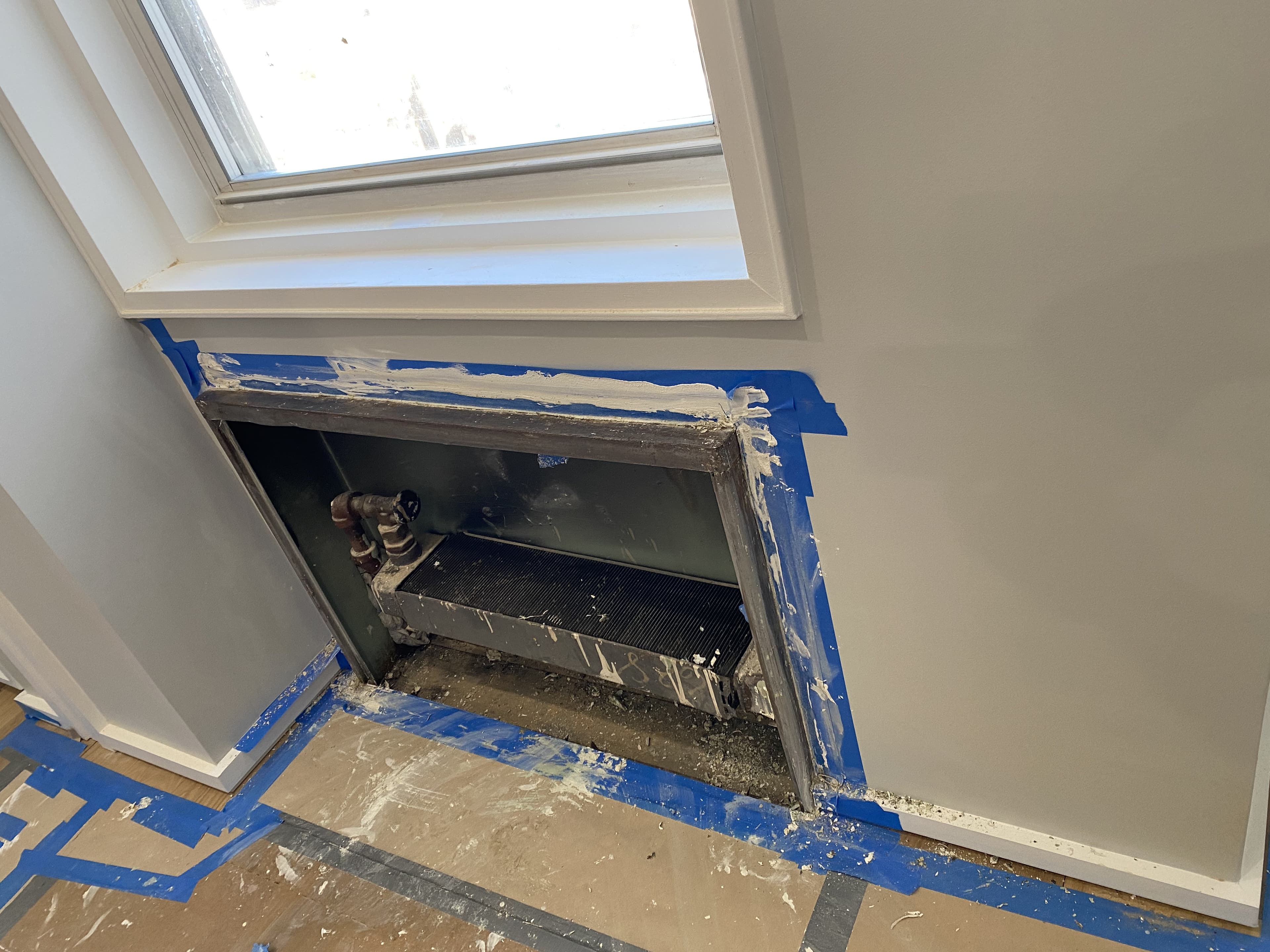 Radiator enclosure work with painter tape and window trim detail