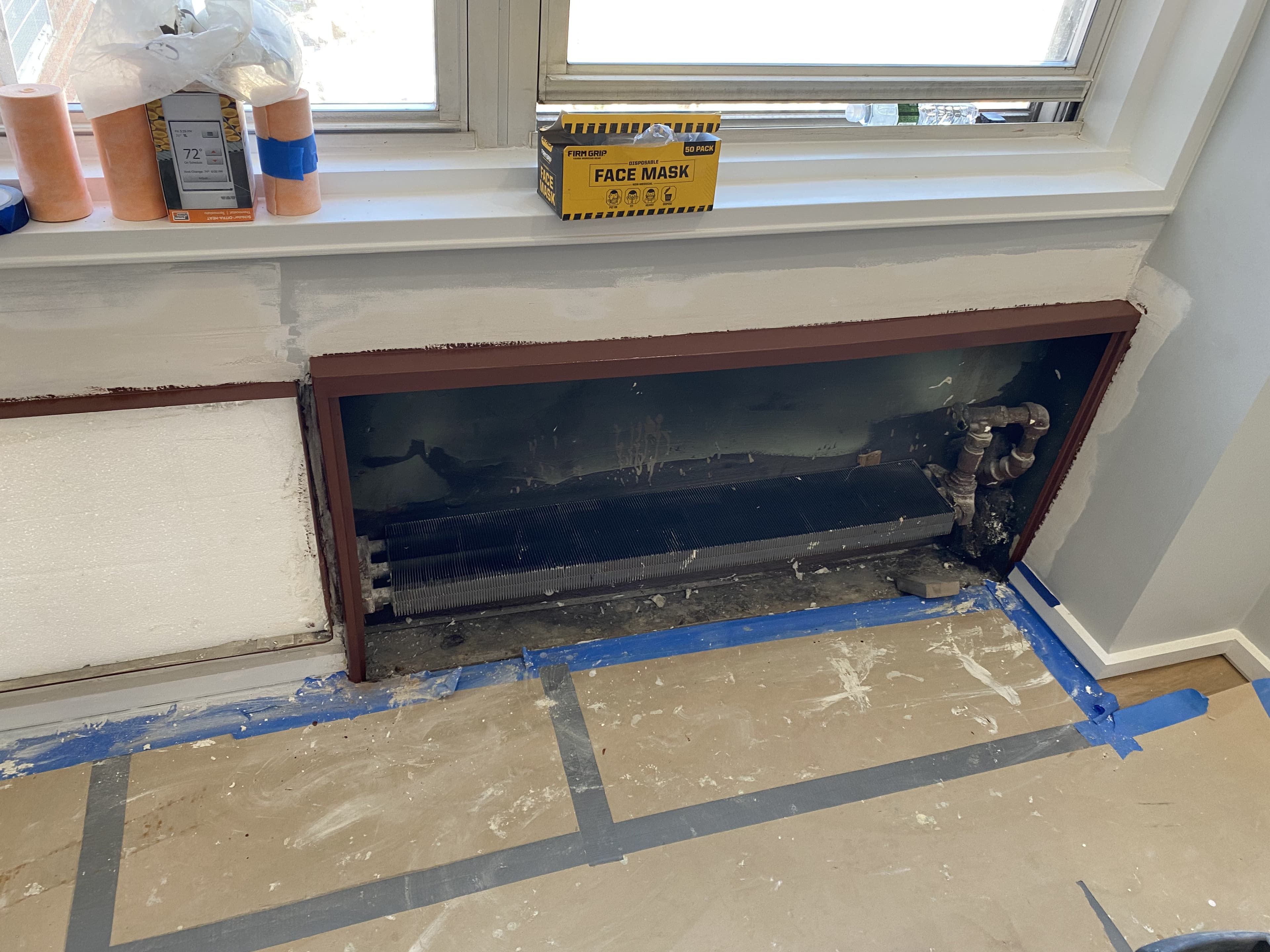 Craftsman painting radiator cover with precision during renovation